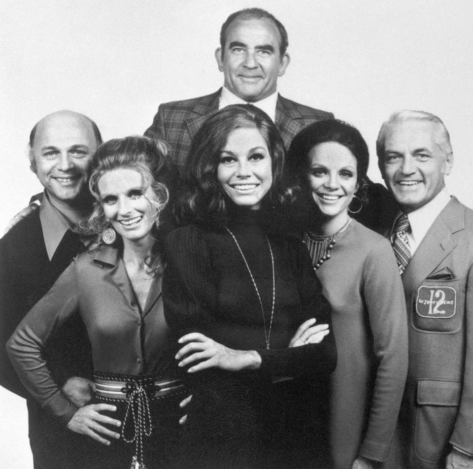 The cast of The Mary Tyler Moore Show, from left to right: Gavin MacLeod, Cloris Leachman, Mary Tyler Moore, Valerie Harper, and Ted Knight. At top, is Ed Asner.
