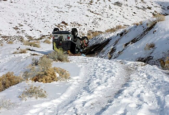 This Tuesday, Dec. 10, 2013 photo provided by searcher Lucia Gonzalez shows the vehicle belonging to a family who went missing after a trip to play in the snow near Lovelock, Nev. James Glanton, his girlfriend Christina McIntee, their two children and a niece and nephew of Christina McIntee, were missing since Sunday and were found by searchers on Tuesday. Their vehicle had overturned and they were stranded in weather that saw temperatures dip to 16 below zero. (AP Photo/Lucia Gonzalez)