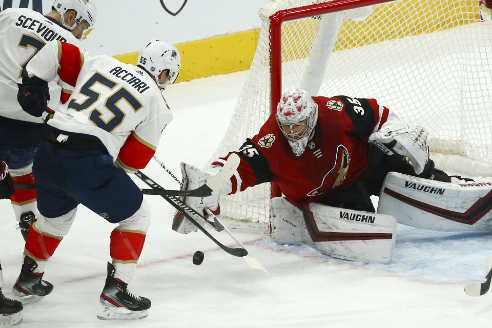 Arizona Coyotes goaltender Darcy Kuemper (35) makes a save as Florida Panthers center Noel Acciari (55) and Panthers center Colton Sceviour (7) try to get the rebound during the first period of an NHL hockey game Tuesday, Feb. 25, 2020, in Glendale, Ariz. (AP Photo/Ross D. Franklin)