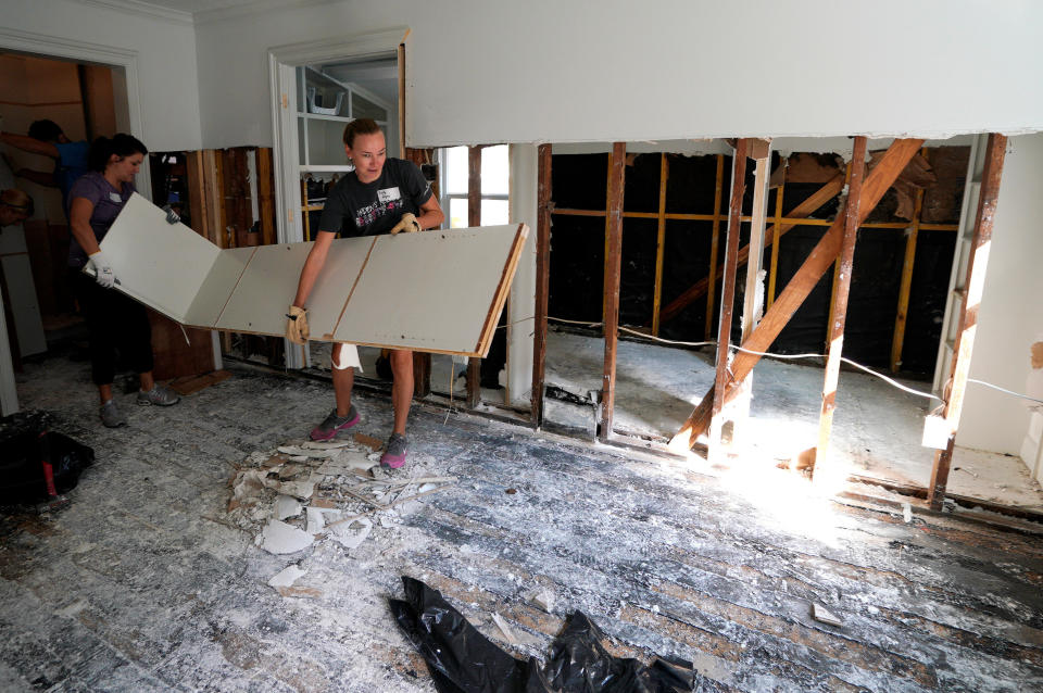 Church volunteers work in&nbsp;a damaged home.