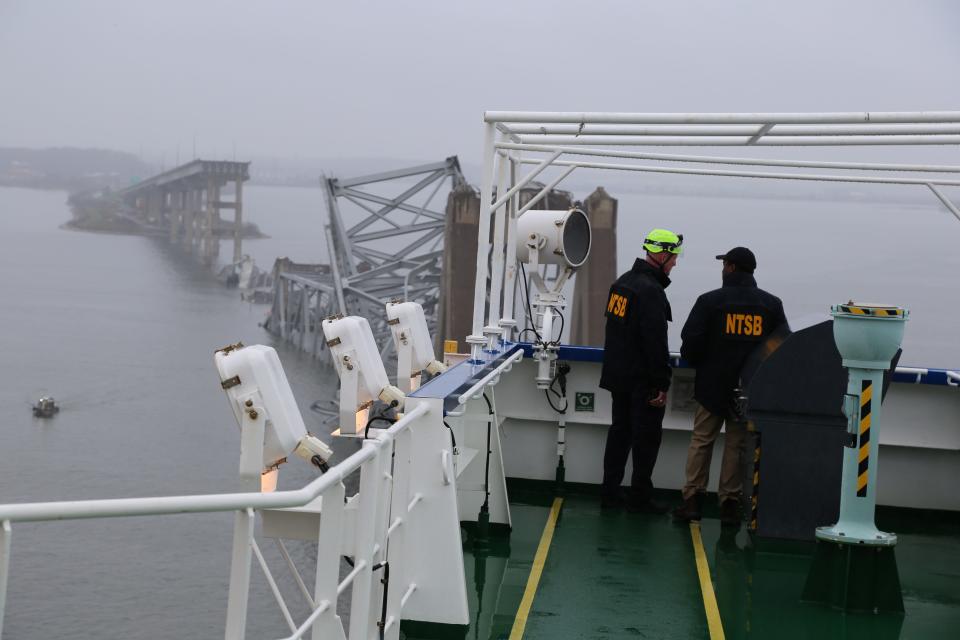 NTSB investigators are seen March 27, 2024, on the cargo vessel Dali, which struck and collapsed the Francis Scott Key Bridge on March 26, 2024.