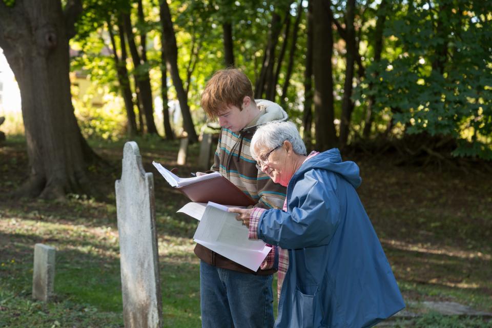 Retiring West Bloomfield Historian Pat Talley assists Troop 56 Eagle Scout candidate Ian Mitchell with restoration projects at West Bloomfield Pioneer Cemetery in 2016 .