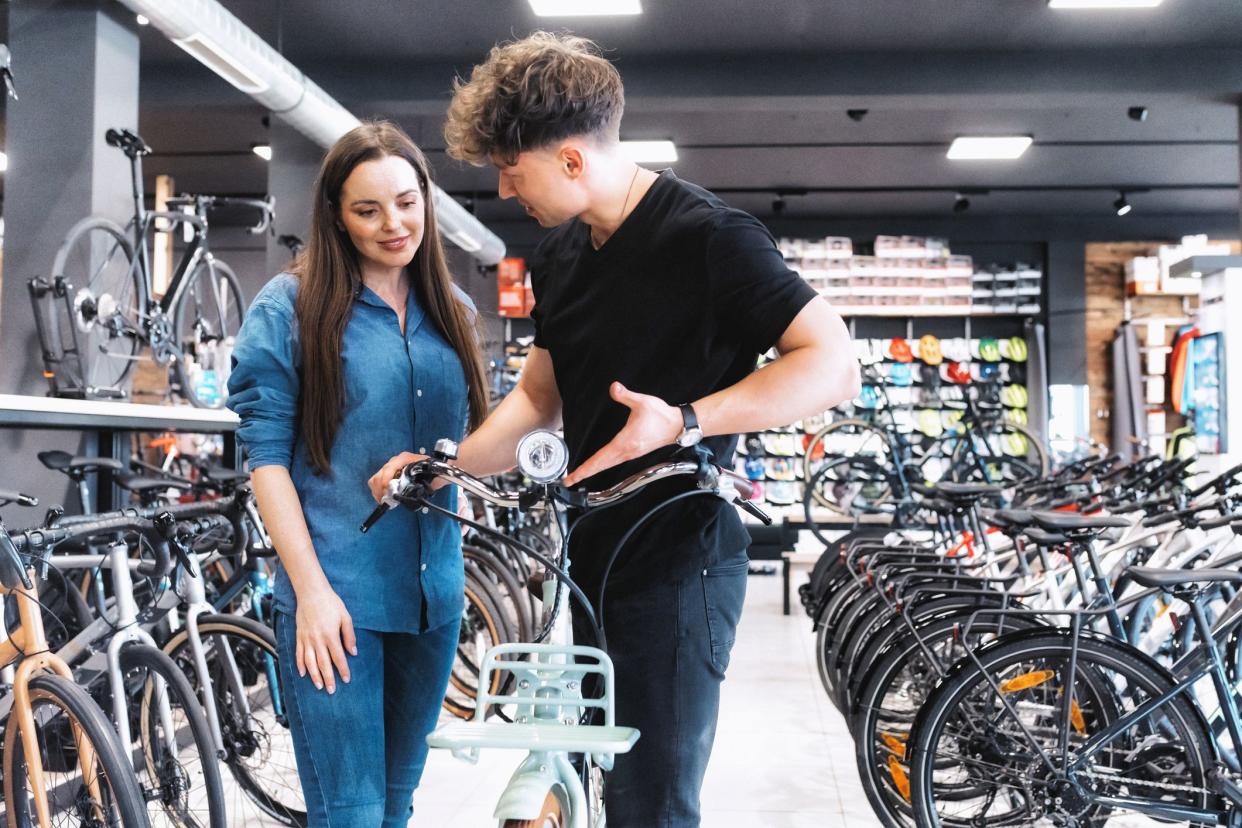 man explaining new e- bike to female customer