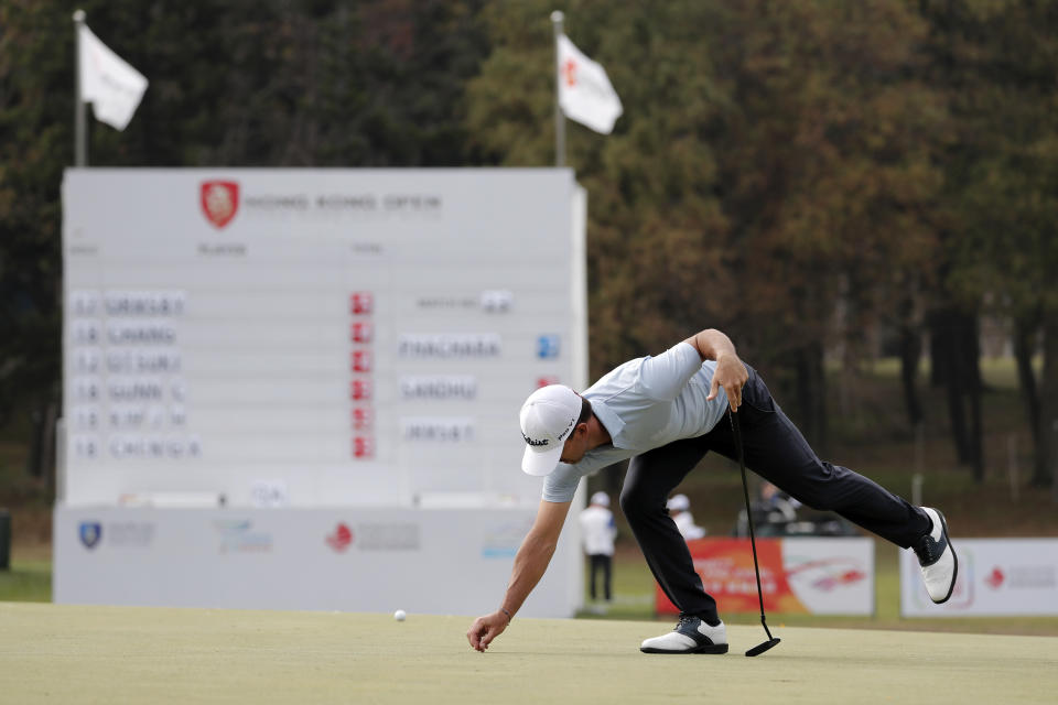 Wade Ormsby of Australia clears for his putt on the 18th hole during the Hong Kong Open golf tournament at Fanling Golf Club in Hong Kong, Thursday, Jan. 9, 2020. (AP Photo/Andy Wong)