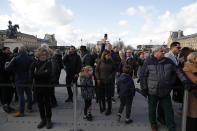 Visitors wait as striking employees demonstrate outside the Louvre museum Friday, Jan. 17, 2020 in Paris. Paris' Louvre museum was closed Friday as dozens of protesters blocked the entrance to denounce the French government's plans to overhaul the pension system. (AP Photo/Francois Mori)