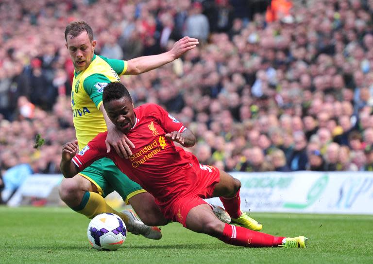 Liverpool's Raheem Sterling (R) is fouled by Norwich City's Steven Whittaker during their English Premier League match, at Carrow Road in Norwich, on April 20, 2014