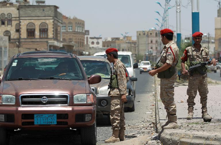 Yemeni soldiers stand guard in the capital Sanaa on April 20, 2014, as they check passing vehicles as authorities tightened security measures a day after a US drone killed Al-Qaeda suspects