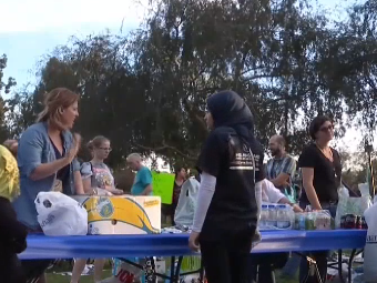 Volunteers offer out food in a park in San Diego: screengrab/NBC