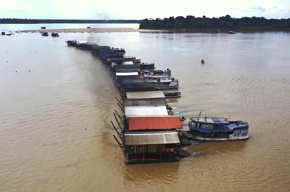 Dredging barges operated by illegal miners converge on the Madeira river, a tributary of the Amazon river, searching for gold, in Autazes, Amazonas state, Brazil, Thursday, Nov.25, 2021. Hundreds of mining barges have arrived during the past two weeks after rumors of gold spread, with environmentalists sounding the alarm about the unprecedented convergence of boats in the sensitive ecosystem. (AP Photo/Edmar Barros)