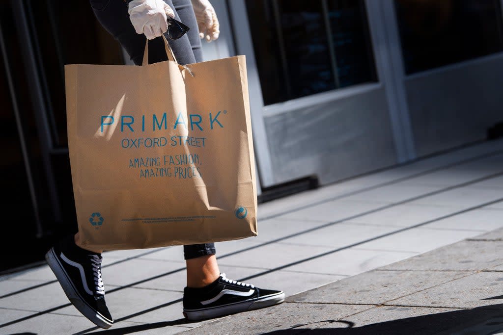 A customer carries bags of shopping as they leave Primark in Oxford Street (Victoria Jones/PA) (PA Archive)