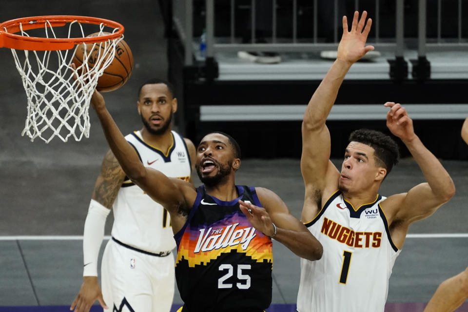 Phoenix Suns forward Mikal Bridges (25) drives past Denver Nuggets forward Michael Porter Jr. (1) during the second half of an NBA basketball game Saturday, Jan. 23, 2021, in Phoenix. (AP Photo/Rick Scuteri)