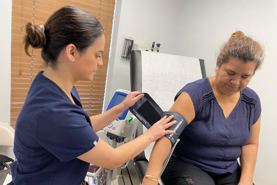 Volunteer Catherine Castillo,  a licensed practical nurse, takes the vital signs for patient Alicia Zuniga at the HOPE Medical Clinic in Destin.