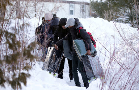 FILE PHOTO: A family from Yemen crosses the U.S.-Canada border into Hemmingford, Quebec, Canada on February 14, 2017. REUTERS/Christinne Muschi/File Photo