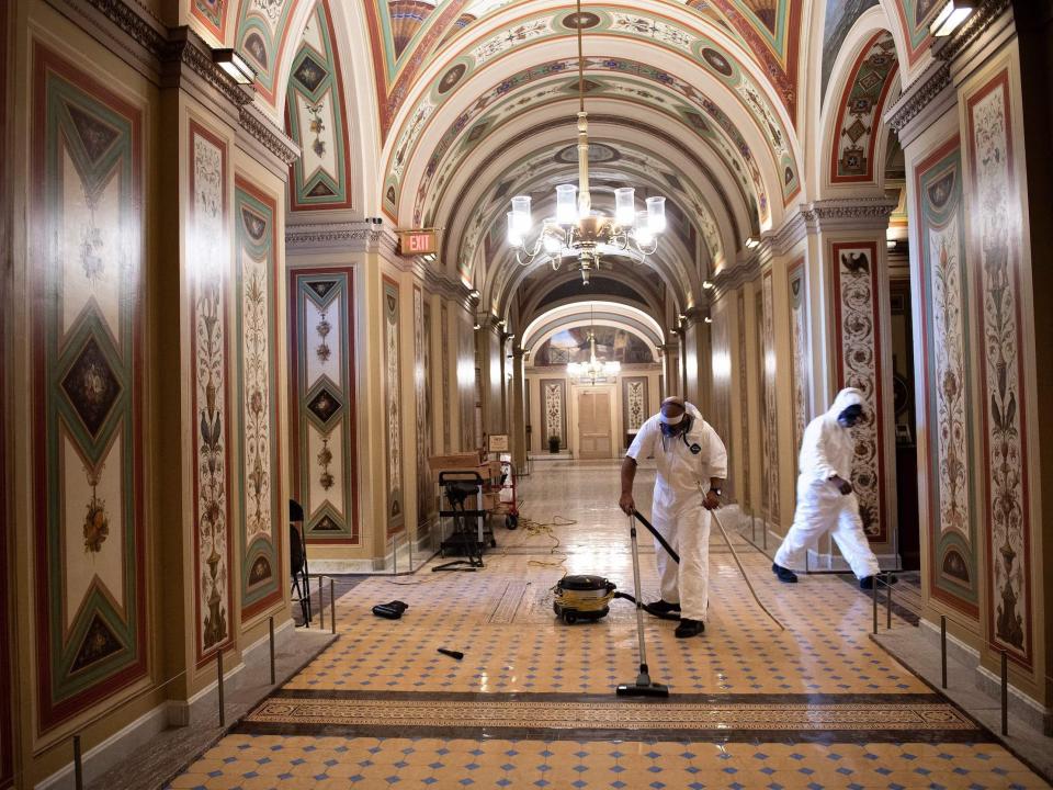 Workers clean damage near an overrun Capitol Police checkpoint a day after a pro-Trump mob broke into the US Capitol