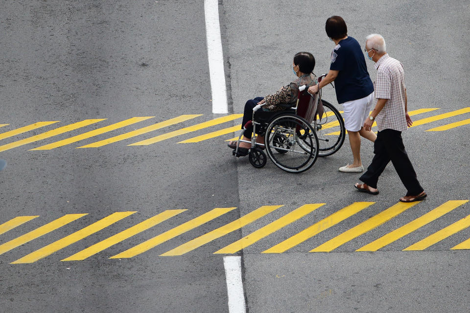 SINGAPORE - JULY 10:  Voters cross a street to go to a polling station during the general election on July 10, 2020 in Singapore. Singaporeans go to the polls today as the ruling party, People's Action Party seeks a fresh mandate amid the coronavirus (COVID-19) pandemic. As of July 9, the total number of COVID-19 cases in the country stands at 45,422.  (Photo by Suhaimi Abdullah/Getty Images)