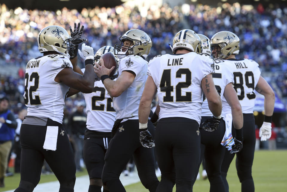 New Orleans Saints quarterback Drew Brees, center, celebrates with teammates after throwing his 500th career touchdown pass in the first half of an NFL football game, Sunday, Oct. 21, 2018, in Baltimore. (AP Photo/Gail Burton)