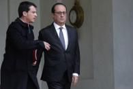 French President Francois Hollande speaks with Prime Minister Manuel Valls (L) at the Elysee Palace in Paris, France, November 14, 2015, following an extraordinary Defence council meeting the day after deadly attacks in the French capital. REUTERS/Philippe Wojazer