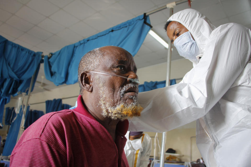 A doctor tends to a patient suffering from COVID-19 in a ward for coronavirus patients at the Martini hospital in Mogadishu, Somalia Wednesday, Feb. 24, 2021. (AP Photo/Farah Abdi Warsameh)