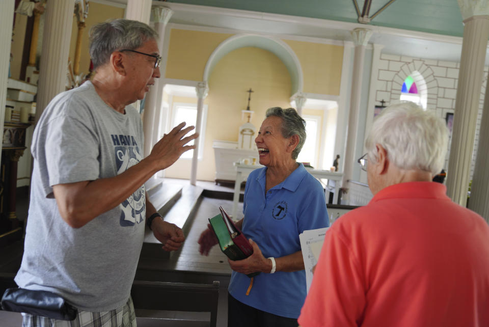 Lance Toyofuku, left, talks with sisters Alicia Damien Lau, center, and Barbara Jean Wajda, right, after Mass at St. Philomena Church during a pilgrimage tour of Kalaupapa, Hawaii on Tuesday, July 18, 2023. The church was expanded and used by St. Damien and his parishioners in the 1800s while he lived with and cared for leprosy patients banished to Kalaupapa. (AP Photo/Jessie Wardarski)