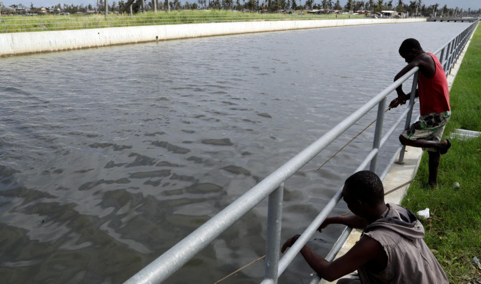 Fishermen fish in a drainage canal in Beira Mozambique, Sunday March 24, 2019. The canal is part of a newly-completed anti flooding system meant to protect the city against from rising waters. Long before Cyclone Idai roared in and tore Beira apart the mayor dreamed of protecting his people from adverse weather conditions. (AP Photo/Themba Hadebe)