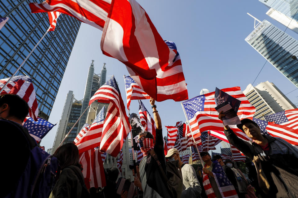 Protesters carrying American flags march to U.S. Consulate during a rally in Hong Kong, Sunday, Dec. 1, 2019. China accused the U.N. high commissioner for human rights of emboldening "radical violence" in Hong Kong by suggesting the city's leader conduct an investigation into reports of excessive use of force by police. (AP Photo/Vincent Thian)