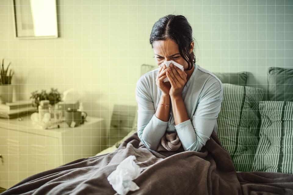 woman blowing her nose in bed