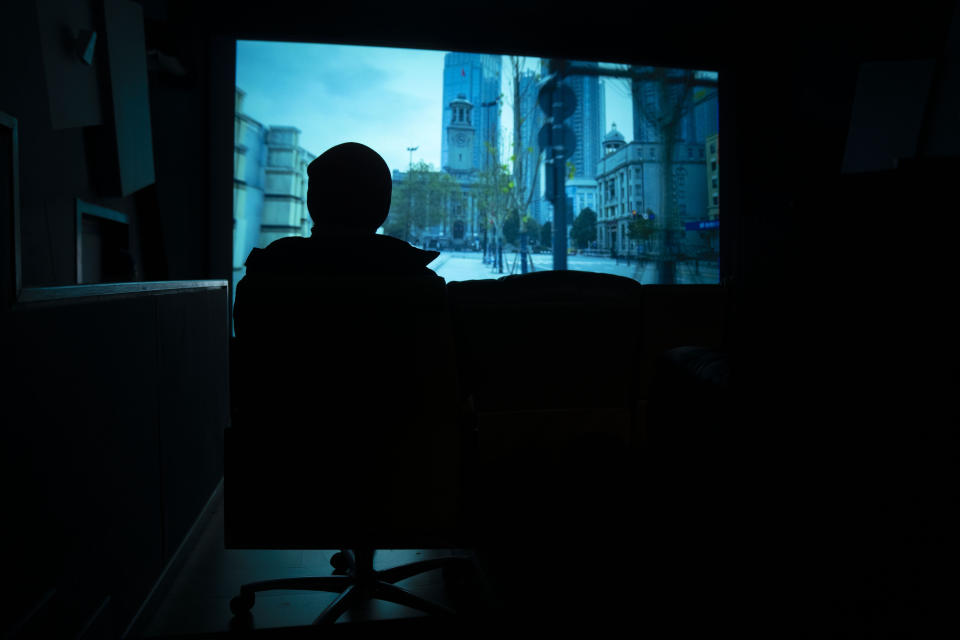 An audience member watches as the documentary film "Wuhan, I Am Here" plays in a screening room in Beijing, Saturday, Jan. 15, 2022. The homeless, the sick, the elderly: For people who fell through the cracks of the official system, the then-unprecedented decision to isolate the central Chinese city of Wuhan and its 13 million people was a matter of life or death. Director Lan Bo hopes to sound the alarm with a documentary about volunteers who helped neighbors get food and medical care following the lockdown in early 2020 of the city where the coronavirus pandemic began. (AP Photo/Mark Schiefelbein)