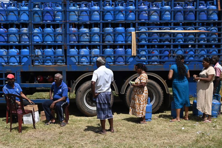 La gente espera en una cola para recoger cilindros de gas licuado de petróleo (GLP) en un punto de distribución en Colombo el 12 de julio de 2022.