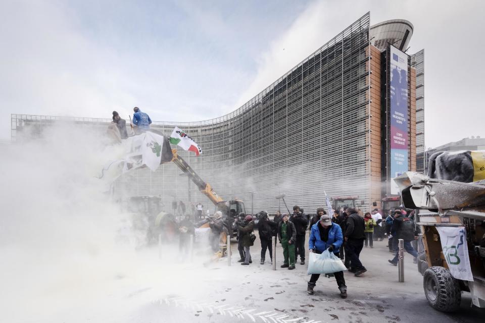 European dairy farmers spray the EU Council building with milk powder to protest the crisis in their sector, in Brussels on Monday, Jan. 23, 2017. The sector has been hit with sagging prices and production costs squeezing profits to the extent that has driven many farmers to the brink of bankruptcy. The EU's executive Commission has approved some support measures over the past year, but the farmers fear that releasing more milk powder on the market would further complicate their plight. (AP Photo/Geert Vanden Wijngaert)