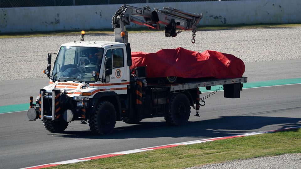 A truck carries the Ferrari of Sebastian Vettel after he crashed into the barriers. (Photo by LLUIS GENE/AFP/Getty Images)