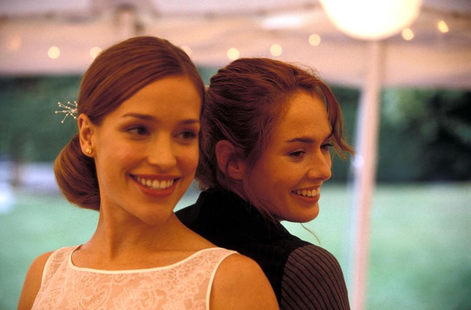 Piper Perabo and Lena Headey in a scene from the movie "Imagine Me & You." The two actresses are standing back-to-back, smiling