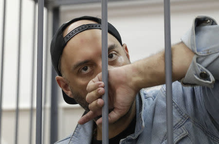 Russian theatre director Kirill Serebrennikov, who was detained and accused of embezzling state funds, looks on inside the defendants' cage as he attends a hearing on his detention at a court in Moscow, Russia August 23, 2017. REUTERS/Tatyana Makeyeva