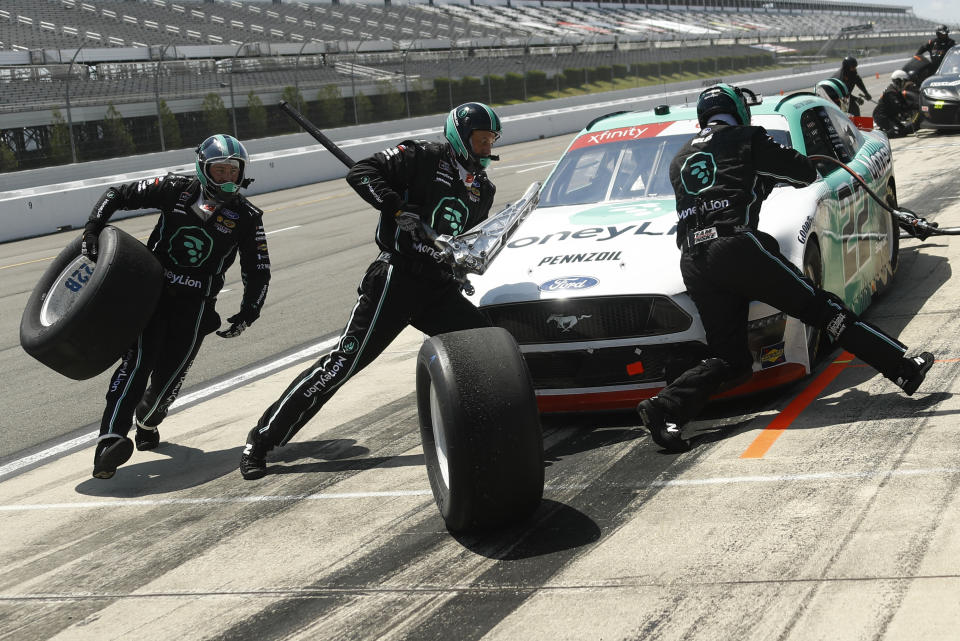 Crew members hustle to service the car of Austin Cindric in a pit stop during the NASCAR Xfinity Series auto race at Pocono Raceway, Sunday, June 28, 2020, in Long Pond, Pa. (AP Photo/Matt Slocum)