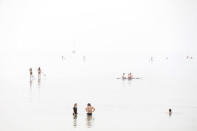 Beachgoers dip in the Mediterranean Sea in Tel Aviv, Israel April 9, 2016. The picture was created by exposing for the shadows on a hazy day. REUTERS/Baz Ratner