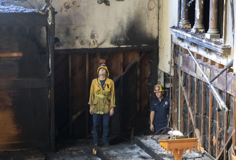 Los Angeles, CA - February 06: Los Angeles City firefighters look over the aftermath of a fire at St. Johns United Methodist Church Sunday, Feb. 6, 2022 in Los Angeles, CA. (Brian van der Brug / Los Angeles Times)