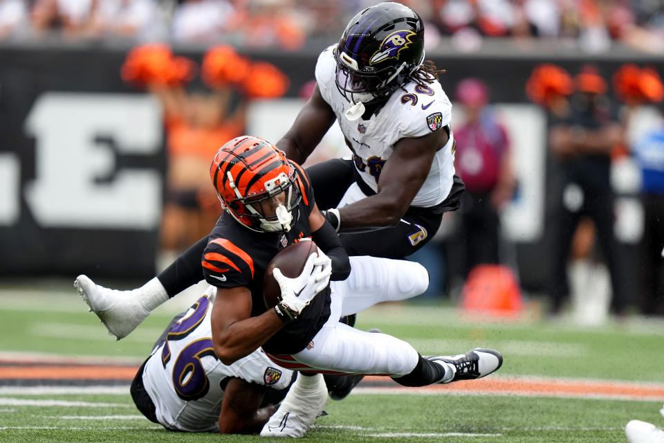 Sep 17, 2023; Cincinnati, Ohio, USA; Cincinnati Bengals wide receiver Tyler Boyd (83) is tackled after a catch by Baltimore Ravens safety Geno Stone (26) and Baltimore Ravens linebacker David Ojabo (90) in the third quarter at Paycor Stadium. Mandatory Credit: Albert Cesare-USA TODAY Sports