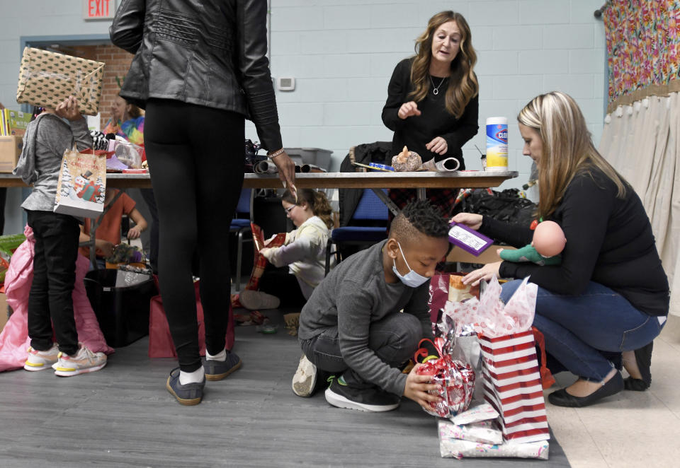 Volunteer Tammy Eberwein, right, of Williamsport, Md., helps Decari Cain, 7, choose gifts for his family during Prison Fellowship's Angel Tree event for children of the incarcerated, Sunday Dec. 19, 2021 at Hub City Vineyard church in Hagerstown, Md. The Prison Fellowship's Angel Tree is expected to deliver gifts to about 300,000 kids nationwide this year. (AP Photo/Steve Ruark)