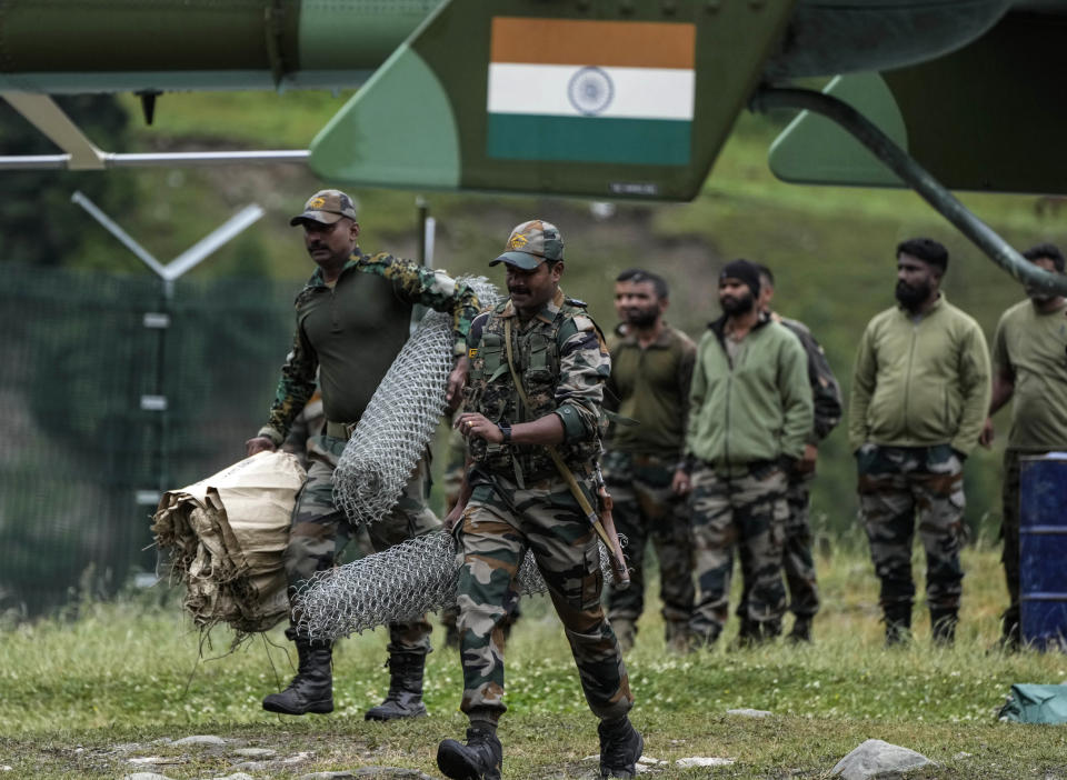 Indian army soldiers leave for a rescue mission from Baltal, 105 kilometers (65miles) northeast of Srinagar, Indian controlled Kashmir, Saturday, July 9, 2022. More than ten pilgrims have been killed and many feared missing after a cloudburst triggered a flash flooding during an annual Hindu pilgrimage to an icy Himalayan cave in Indian-controlled Kashmir. Officials say the cloudburst near the hollowed mountain cave revered by Hindus on Friday sent a wall of water down a mountain gorge and swept about two dozen encampments and two makeshift kitchens. (AP Photo/Mukhtar Khan)