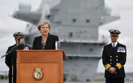 Britain's Prime Minister Theresa May stands on the flight deck as she speaks to crew members of the British aircraft carrier HMS Queen Elizabeth, during her tour of the ship, after it arrived at Portsmouth Naval base, its new home port, in Portsmouth, Britain August 16, 2017. REUTERS/Ben Stansall/Pool