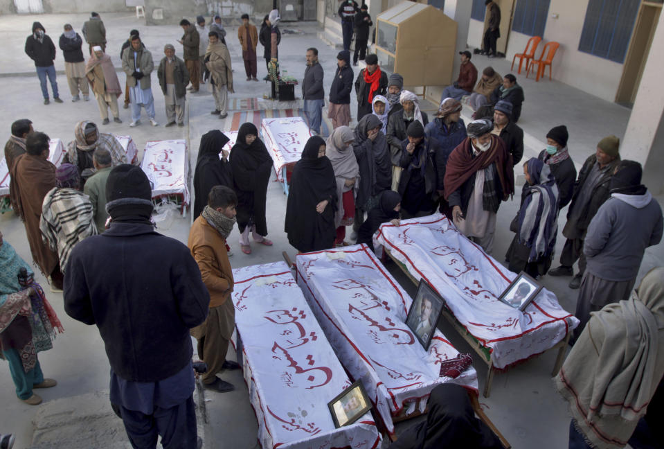 People from the Shiite Hazara community mourn beside the coffins of coal mine workers who were killed by gunmen near the Machh coal field prior to their funeral prayer in Quetta, Pakistan, Saturday, Jan. 9, 2021. Hundreds of Pakistani Shiites gathered to bury 11 coal miners from the minority Hazara community who were killed by the Islamic State group, ending over a week of protests that sought to highlight the minority community's plight. (AP Photo/Arshad Butt)