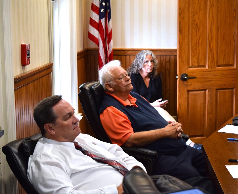 Holmes County Commissioners Dave Hall and Joe Miller and human resources manager Misty Burns watch and listen as Matt Minard of KLH Engineers discusses the lighting project of the Holmes County Courthouse.