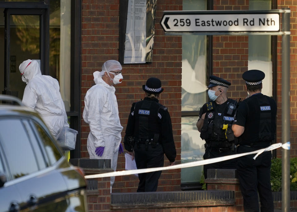 Police officers talk at the scene outside the Belfairs Methodist Church in Eastwood Road North, where British Conservative lawmaker David Amess has died after being stabbed at a constituency surgery, in Leigh-on-Sea, Essex, England, Friday, Oct. 15, 2021. Police gave no immediate details on the motive for the killing of 69-year-old Conservative lawmaker Amess and did not identify the suspect, who was being held on suspicion of murder. (AP Photo/Alberto Pezzali)