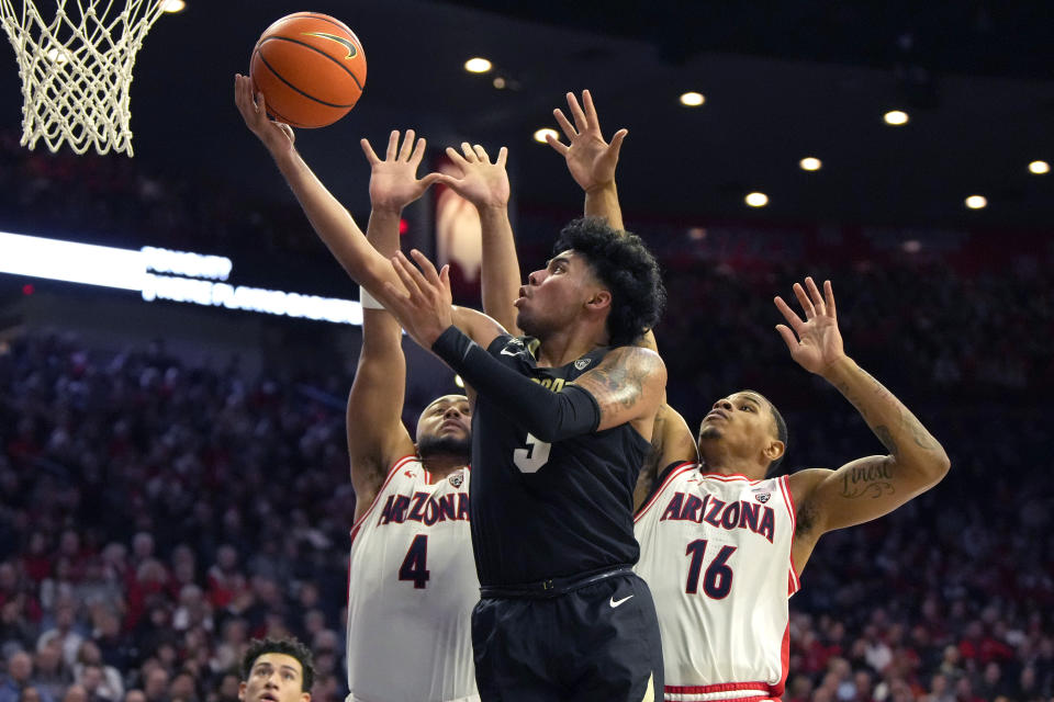 Colorado guard Julian Hammond III (3) drives past Arizona guard Kylan Boswell (4) and forward Keshad Johnson during the first half of an NCAA college basketball game, Thursday, Jan. 4, 2024, in Tucson, Ariz. (AP Photo/Rick Scuteri)