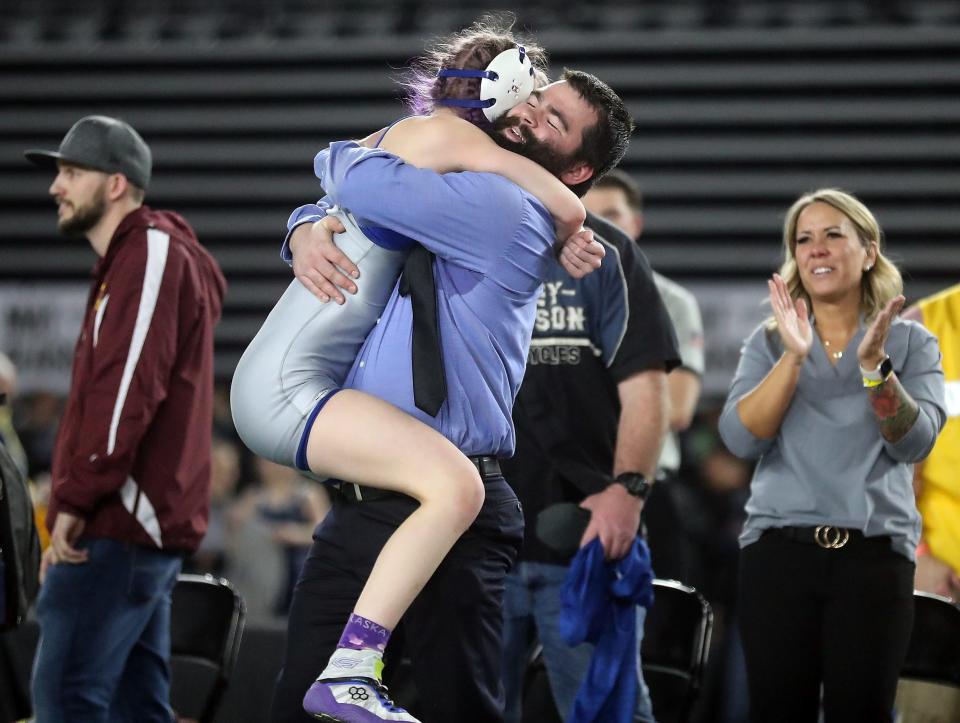 Olympic's Alexandria Templeton jumps into head coach Caleb O'Halek's arms after her win over White River's Lilyana Lamothe during Mat Classic at the Tacoma Dome on Saturday, Feb. 18, 2023.