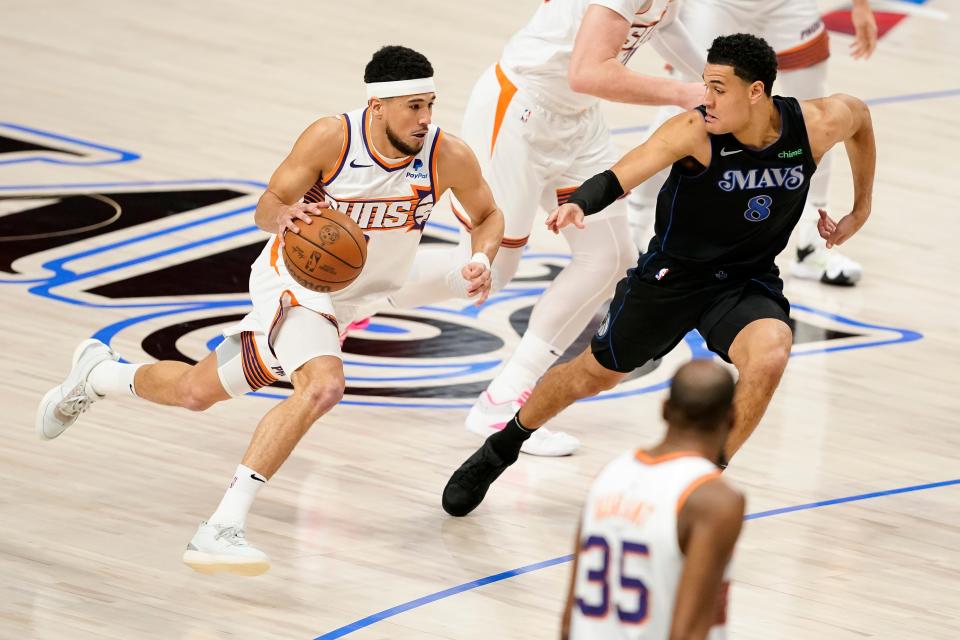 Devin Booker #1 of the Phoenix Suns drives with the ball as Josh Green #8 of the Dallas Mavericks defends during the first half at American Airlines Center on Jan. 24, 2024 in Dallas, Texas.