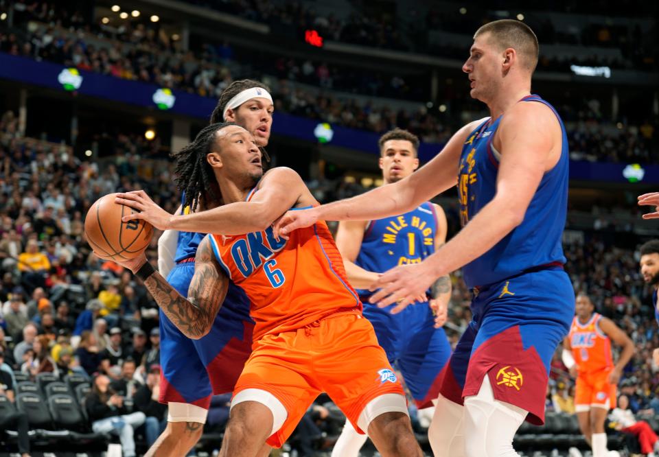 Oklahoma City Thunder forward Jaylin Williams, front left, pulls in a rebound as Denver Nuggets forwards Aaron Gordon, back left, and Michael Porter Jr., back right, and center Nikola Jokic, front right, defend in the second half of an NBA basketball game Saturday, Dec. 16, 2023, in Denver. (AP Photo/David Zalubowski)