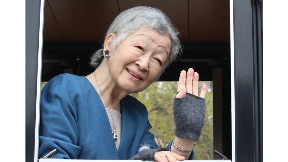 Empress Michiko waving from a car