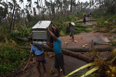 People carry their belongings to a safer place after cyclone Titli hit in Srikakulam district in Andhra Pradesh, India, October 11, 2018. REUTERS/Stringer