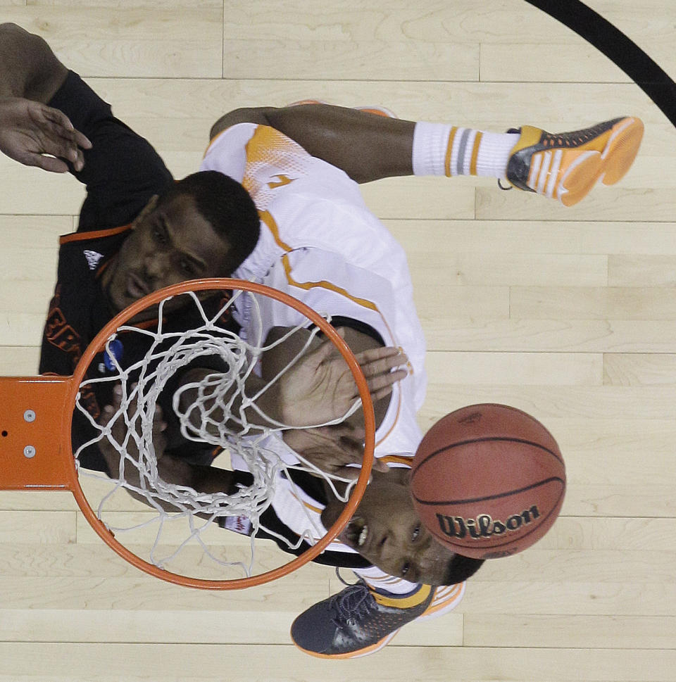 Tennessee forward Jeronne Maymon (34) shoots against Mercer forward Darious Moten (22) during the first half of an NCAA college basketball third-round tournament game, Sunday, March 23, 2014, in Raleigh. (AP Photo/Chuck Burton)