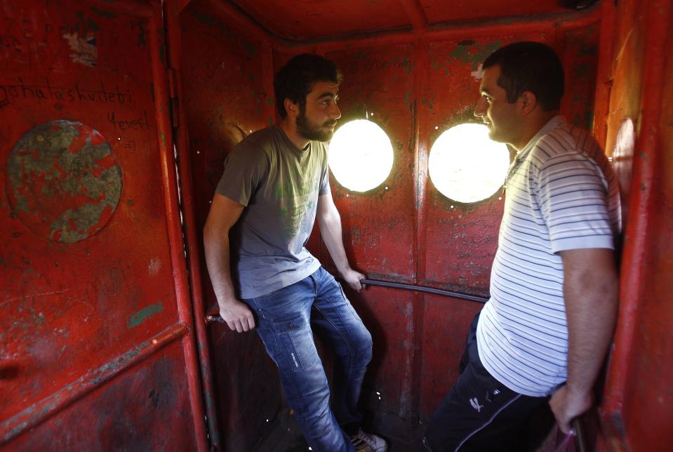 Commuters chat inside a cable car in the town of Chiatura